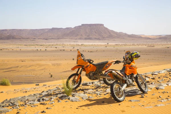 Two orange motobikes in the middle of the sandy and rocky Moroccan desert — Stock Photo, Image