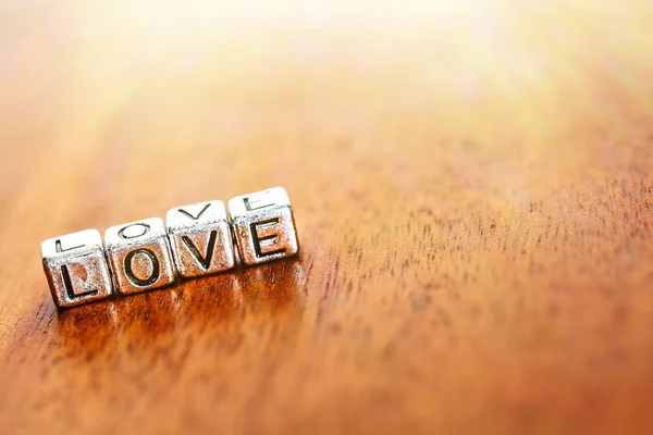 La palabra LOVE se retuerce con miradas metálicas sobre el fondo de madera vieja y el espacio de copia — Foto de Stock