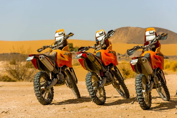 Drie oranje motorfietsen in de Saharawoestijn — Stockfoto