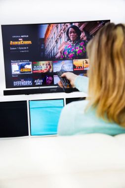 Bir Tv uzaktan kumanda ve oyun Marvel film Netflix üzerinde tutan kadın