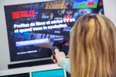 Bir Tv uzaktan kumanda Holding ve Fransa Netflix ana sayfasında kanallar anahtarlama kadın