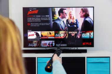 Bir Tv uzaktan kumanda ve oyun Marvel film Netflix üzerinde tutan kadın