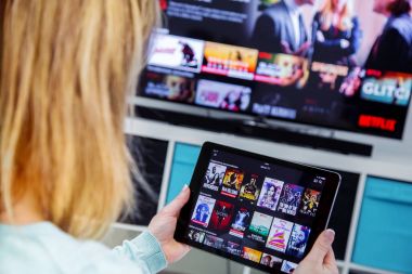 Dokunmatik yüzey Holding ve Fransa Netflix ana sayfasında kanallar anahtarlama kadın. Tv ve arka plan ayarla.