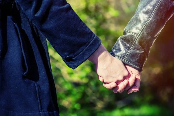 Young couple holding hands  in the park — Stock Photo, Image