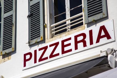 Beyaz tahta üzerinde kırmızı harflerle pizzacı tabela