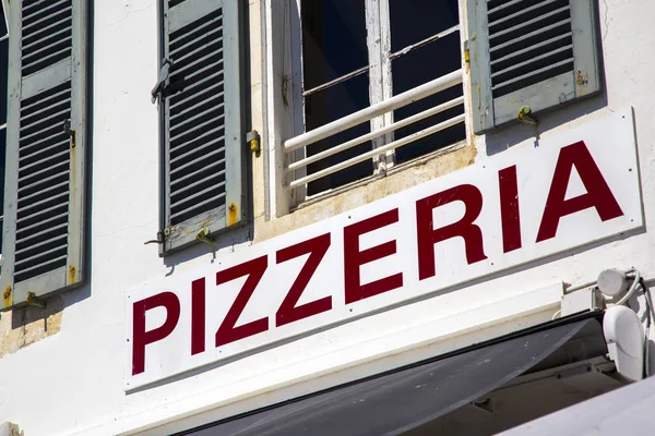 Pizzeria bewegwijzering in rode letters op wit bord — Stockfoto