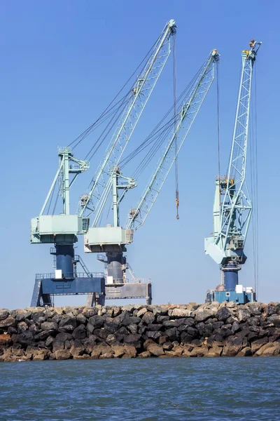 Grúas industriales en un muelle de carga y descarga — Foto de Stock