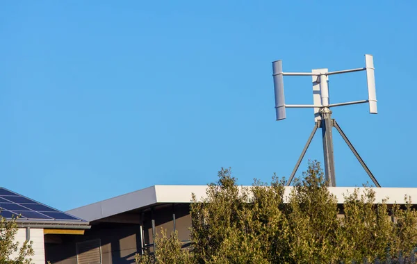Low energy modern building with a mini wind turbine on the roof — Stock Photo, Image