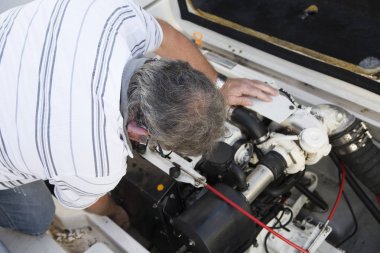 güneşli bir gün altında bir tekne motoru tamir bir adam Close-up