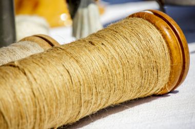 Güneşli bir gün altında beyaz kumaş üzerine jüt sicim rulo