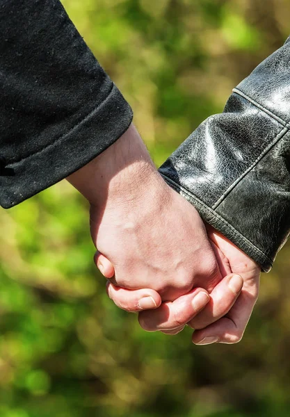 Young couple holding hands  in the park — Stock Photo, Image