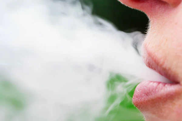 Mujer fumando humo de los labios — Foto de Stock