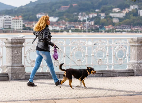 Mulher andando com cão perto do rio — Fotografia de Stock