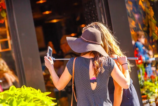 Mujer tomando selfie usando selfie stick — Foto de Stock