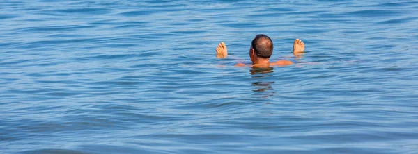 Расслабляющий человек в морской воде — стоковое фото