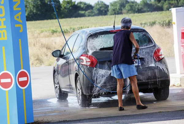 Mujer mayor lavado de coches en el centro de servicio —  Fotos de Stock