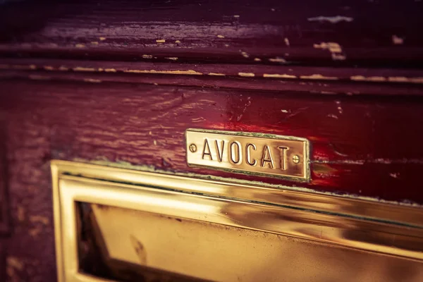 Vanha postilaatikko ovessa lakimiehen nimi ("Avocat" ranskaksi ) — kuvapankkivalokuva