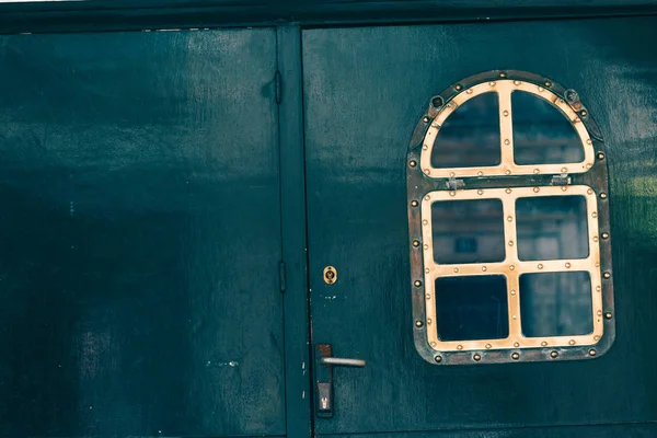 Красивая входная дверь с красивым винтажным латунным окном — стоковое фото