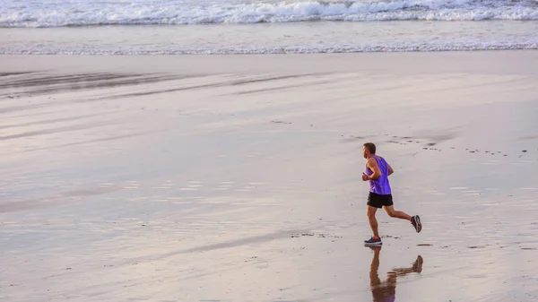 Älterer Mann joggt allein am Strand — Stockfoto