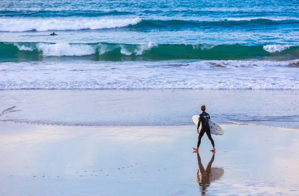 Surfista portando la sua tavola su una spiaggia — Foto Stock