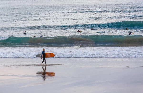 Surfer uitvoering zijn bestuur op een strand — Stockfoto