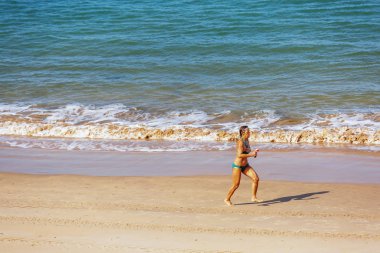 Sahilde tek başına çalışan bir üst düzey kadın.