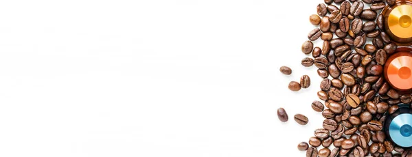 Капсулы кофе и кофейных зерен на белом фоне — стоковое фото