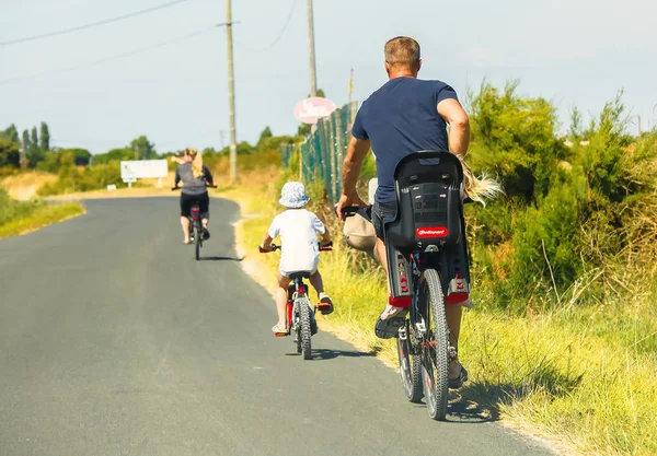 Family enjoying bicycle ride in park — Stock Photo, Image