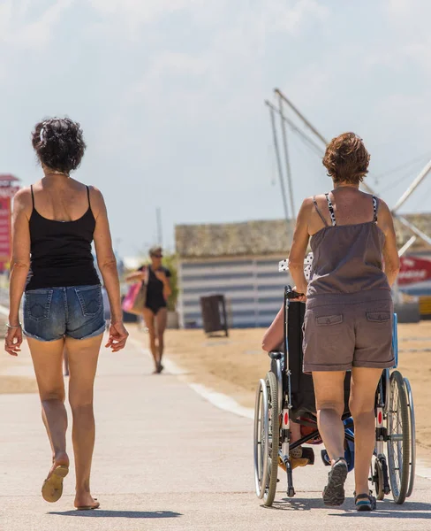 Senior woman walking at beach side road — Stock Photo, Image