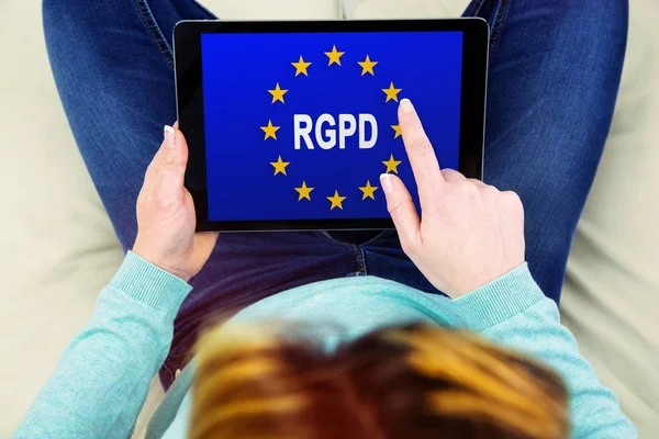 Woman using a touch pad with Flag of European Union with RGPD word inside on the screen