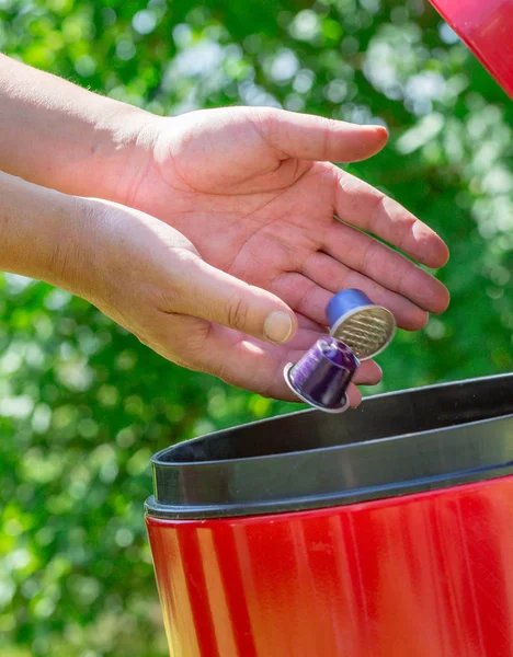 Metalen espresso koffie capsules zetten in de Prullenbak met greeny achtergrond — Stockfoto