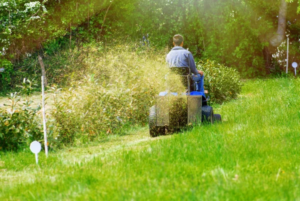 Widok mężczyzny siedzi na jego Traktorek koszenie trawnika jego i z tyłu — Zdjęcie stockowe
