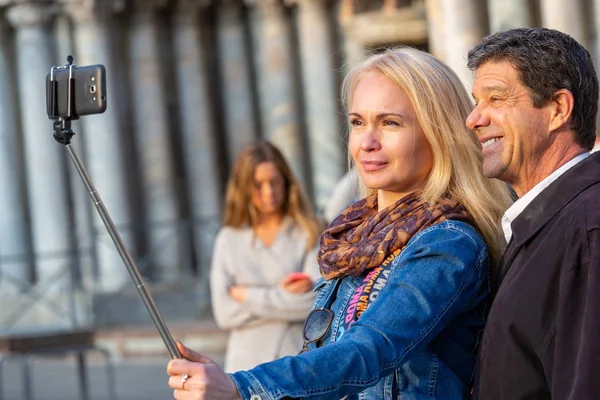 Casal maduro tomando selfie na praça — Fotografia de Stock