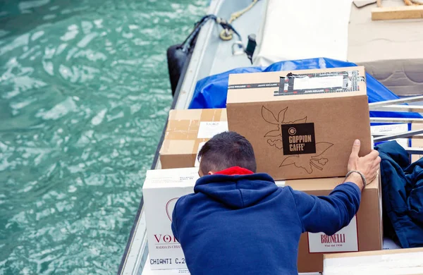 Unrecognizable courier arranging boxes on boat — Stock Photo, Image