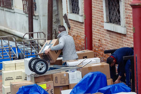 Delivery men unloading parcels from a boat to a restaurant back — Stock Photo, Image