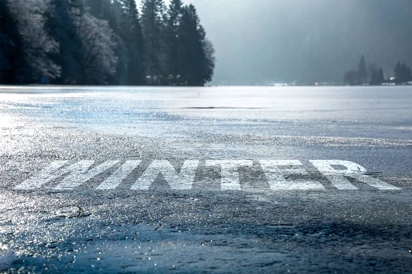 Wort Winter eingeschrieben in den gefrorenen Boden eines Sees — Stockfoto