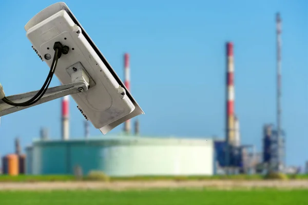 Cctv kamera koncept med luddig olja lagringstankar på bakgrunden — Stockfoto
