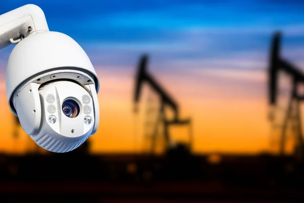 Cctv camera concept met silhouetten van olieput — Stockfoto