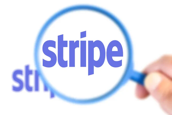 Stripe logotyp förstorad med förstoringsglas — Stockfoto