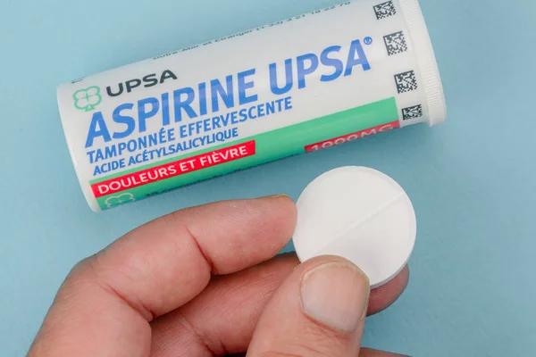 Closeup on aspirin box upsa. It is an antipyretic and pain killer holding in hand — ストック写真