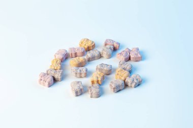 Beyaz arka planda açık mavi renkli hayvan formunda çocuk vitaminleri.