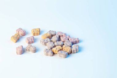 Beyaz arka planda açık mavi renkli hayvan formunda çocuk vitaminleri.