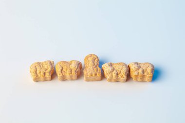 Beyaz arka planda açık mavi renkli hayvan formunda çocuk vitaminleri.