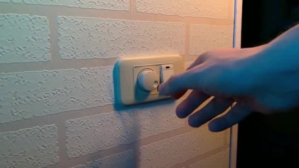 Mão masculina close-up gira interruptor dimmer interruptor de luz — Vídeo de Stock