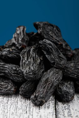 Beyaz üzerine siyah kuru üzümler Ahşap bir arka plan