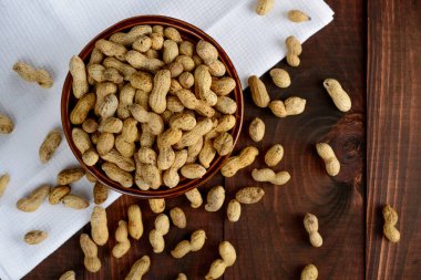 Arka planda bir kasede yer fıstığı. Kabuklu fıstıklar. Sağlıklı yemek..
