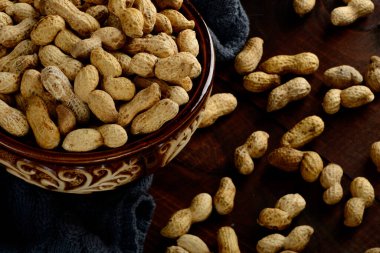 Arka planda bir kasede yer fıstığı. Kabuklu fıstıklar. Sağlıklı yemek..