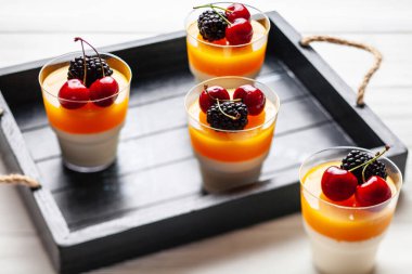 Tahta tepside böğürtlen ve kirazlı 4 bardak mango pannacota.