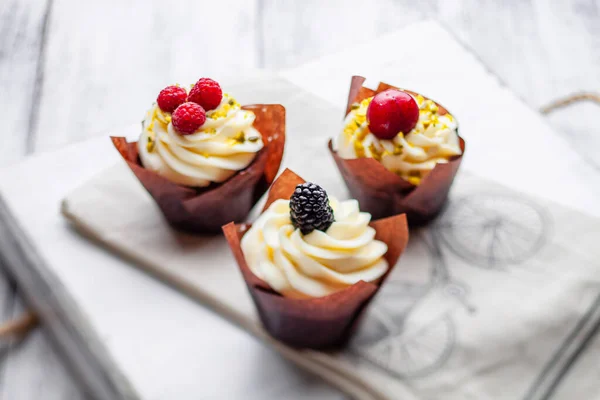 muffins with Belgian chocolate and white chocolate cream and mascarpone with berries on a wooden tray