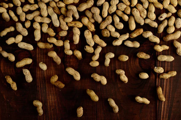Peanuts on a dark background. Peanuts in a shell. Healthy food.